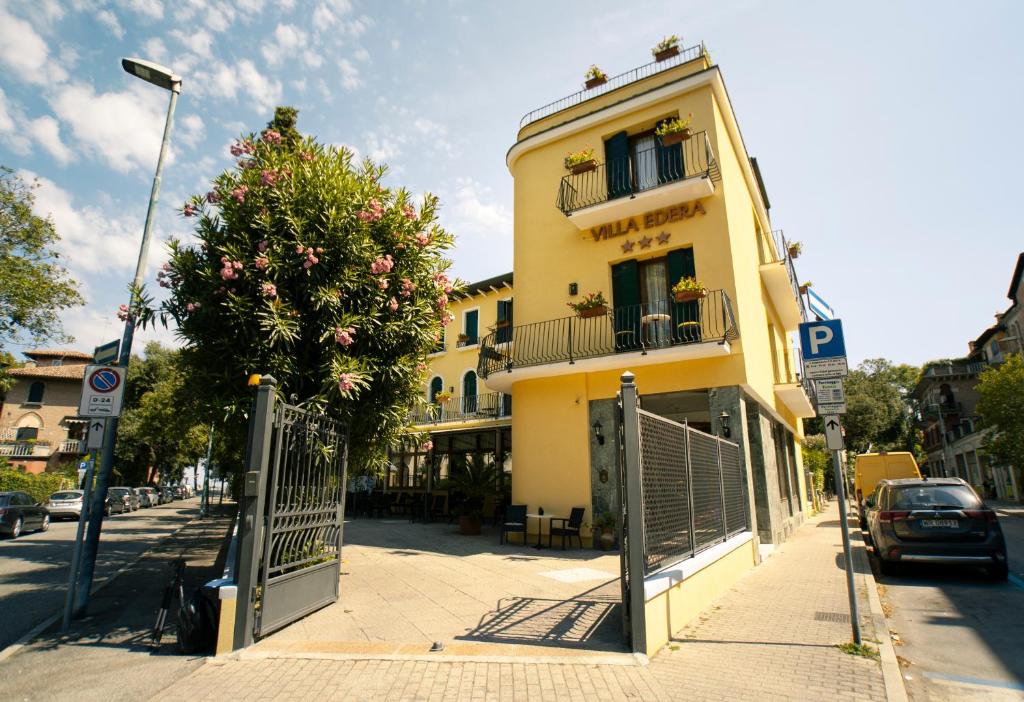 żółty budynek przy ulicy miejskiej z bramą w obiekcie Hotel Villa Edera w Lido di Venezia
