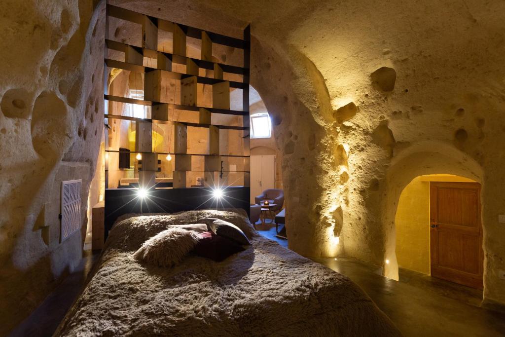 a woman laying on a bed in a stone room at Grotta Barisano in Matera