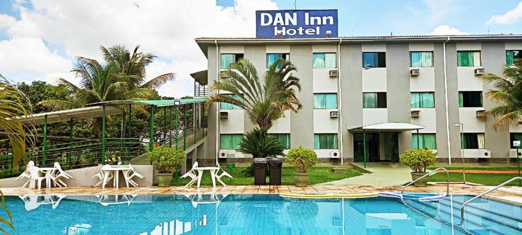 a hotel with a swimming pool in front of a building at Hotel Dan Inn Uberaba & Convenções in Uberaba