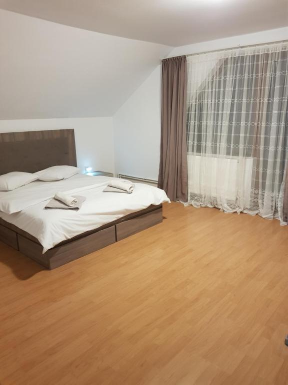 - une chambre avec un lit et une grande fenêtre dans l'établissement Cabana ''langa brad'', à Cavnic