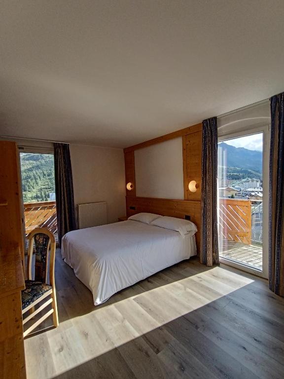 a bedroom with a bed and a large window at Hotel Cielo Blu in Passo del Tonale
