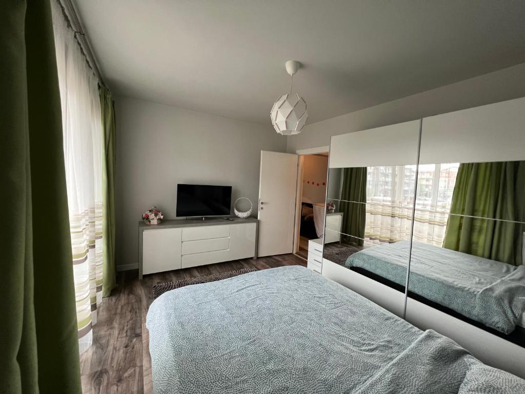 a bedroom with a bed and a flat screen tv at Apartament spatios, mobilat si utilat complet in Floreşti