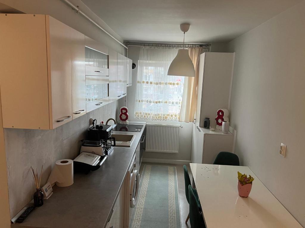 a kitchen with white cabinets and a counter top at Apartament spatios, mobilat si utilat complet in Floreşti