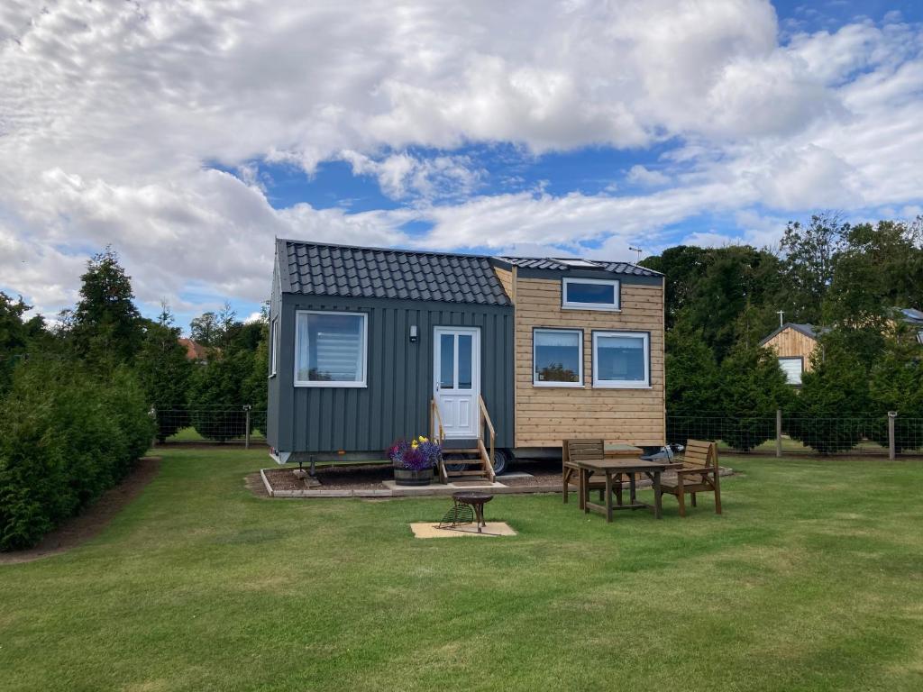 a tiny house with a picnic table in a yard at The Cedar Tiny House in Coldingham