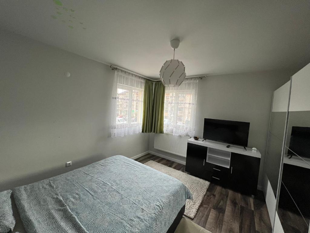 a bedroom with a bed and a flat screen tv at Apartament spatios, mobilat si utilat complet in Floreşti