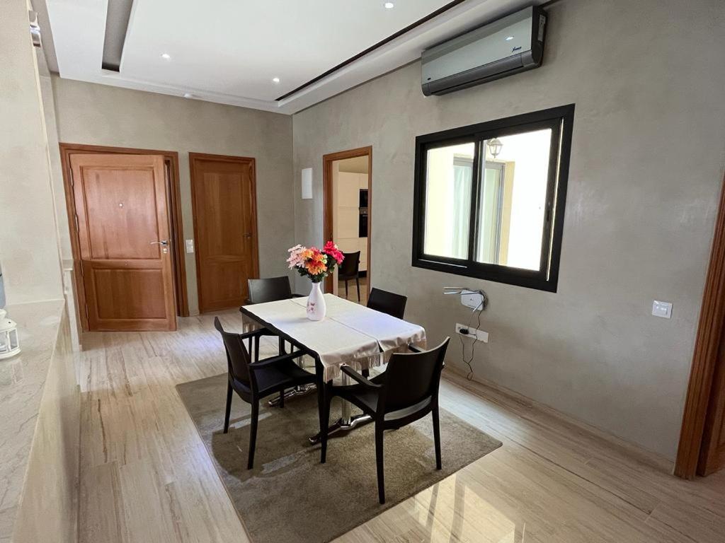 a dining room with a table and chairs and a window at Suites Appartement Midelt in Midelt