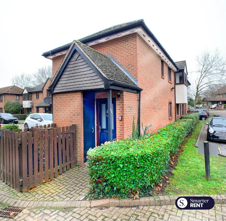 a brick house with a blue door and a fence at Maidenhead - 1 Bed Modern Flat - Private Entrance in Maidenhead