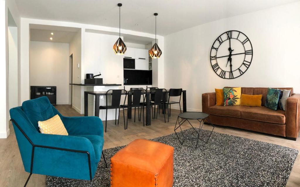 salon z kanapą i zegarem na ścianie w obiekcie Elégant appartement dans le quartier Concorde à Paris w Paryżu