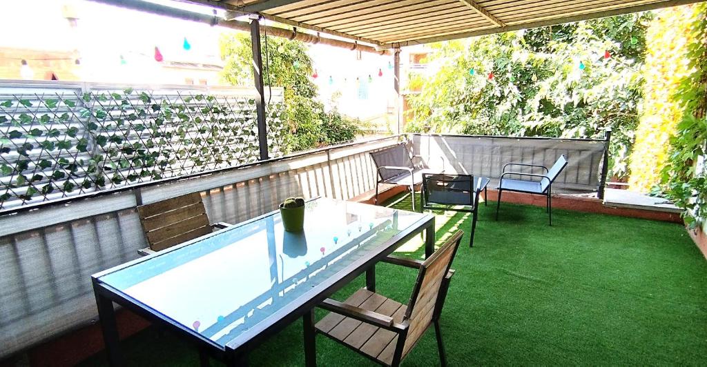 Apartamento entero con terraza en el centro de Rubí في روبي: شرفة مع طاولة وكراسي على الفناء