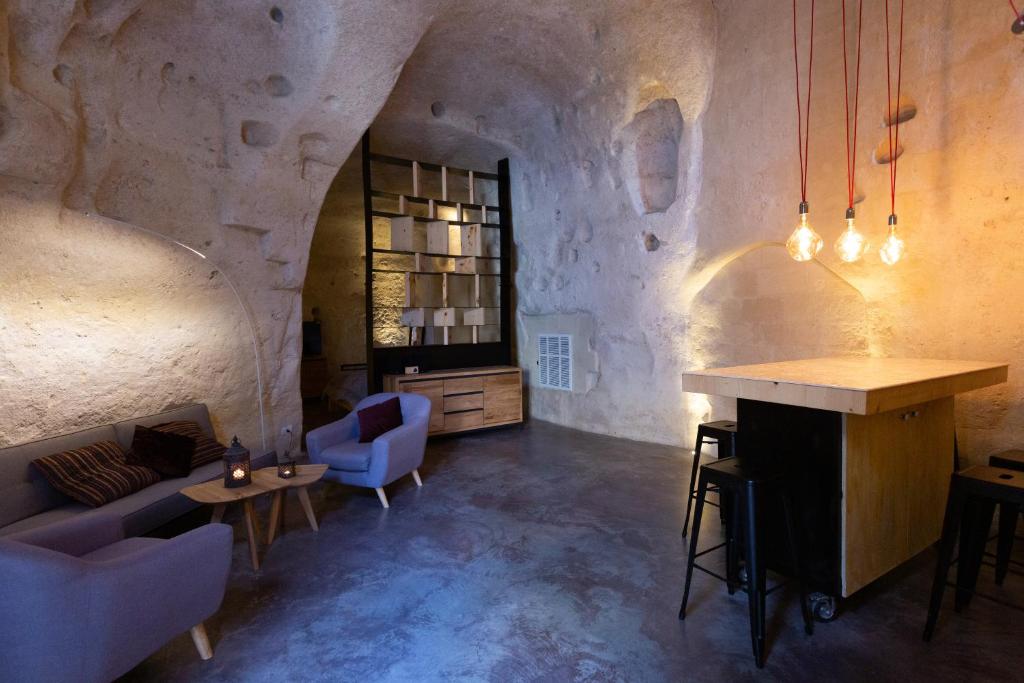 salon z kanapą, stołem i krzesłami w obiekcie Grotta Barisano w mieście Matera