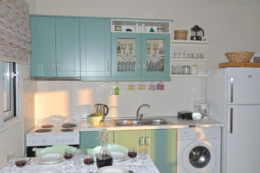 a kitchen with blue cabinets and a sink at Orange apartment in Zarós