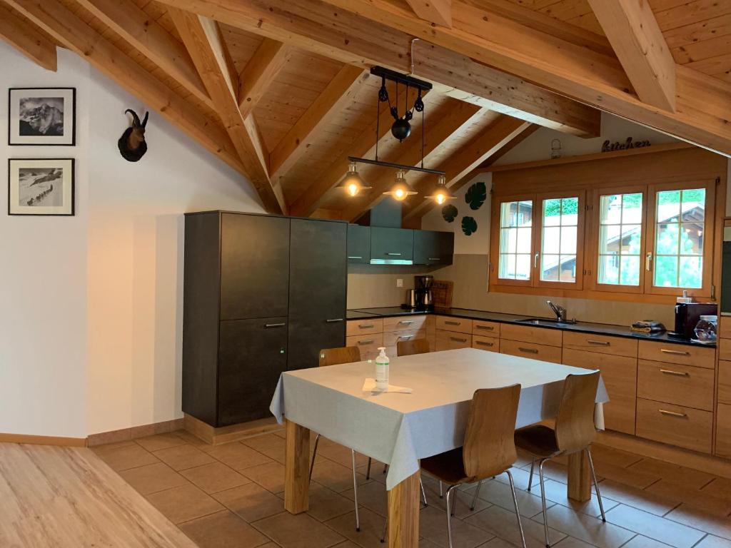 eine Küche mit einem weißen Tisch und Holzdecken in der Unterkunft Ferienwohnung Talhaus in Lauterbrunnen