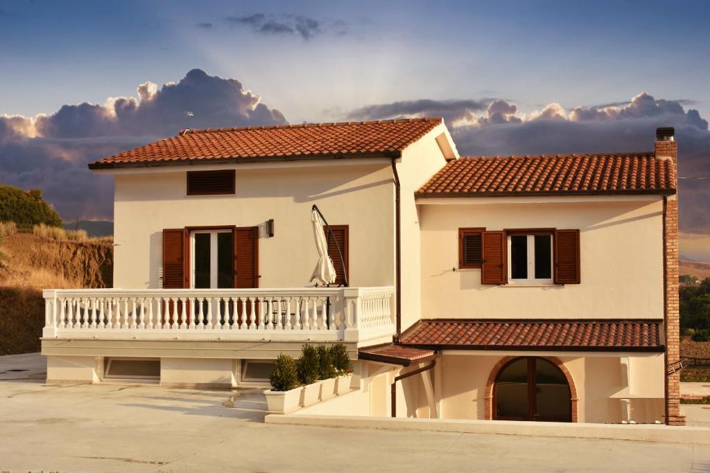 een wit huis met een balkon aan de zijkant bij Il Casale dei Calanchi in Aliano