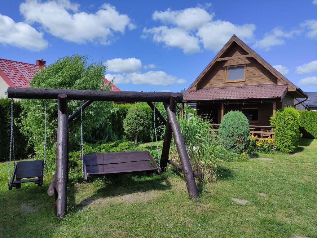 a swing in a yard in front of a house at Domki letniskowe w Kopalinie in Kopalino