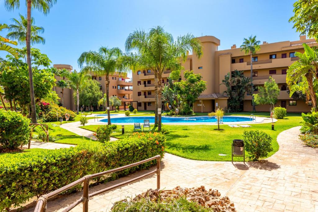 kompleks apartamentów z basenem i palmami w obiekcie Cala Azul w mieście Mijas Costa