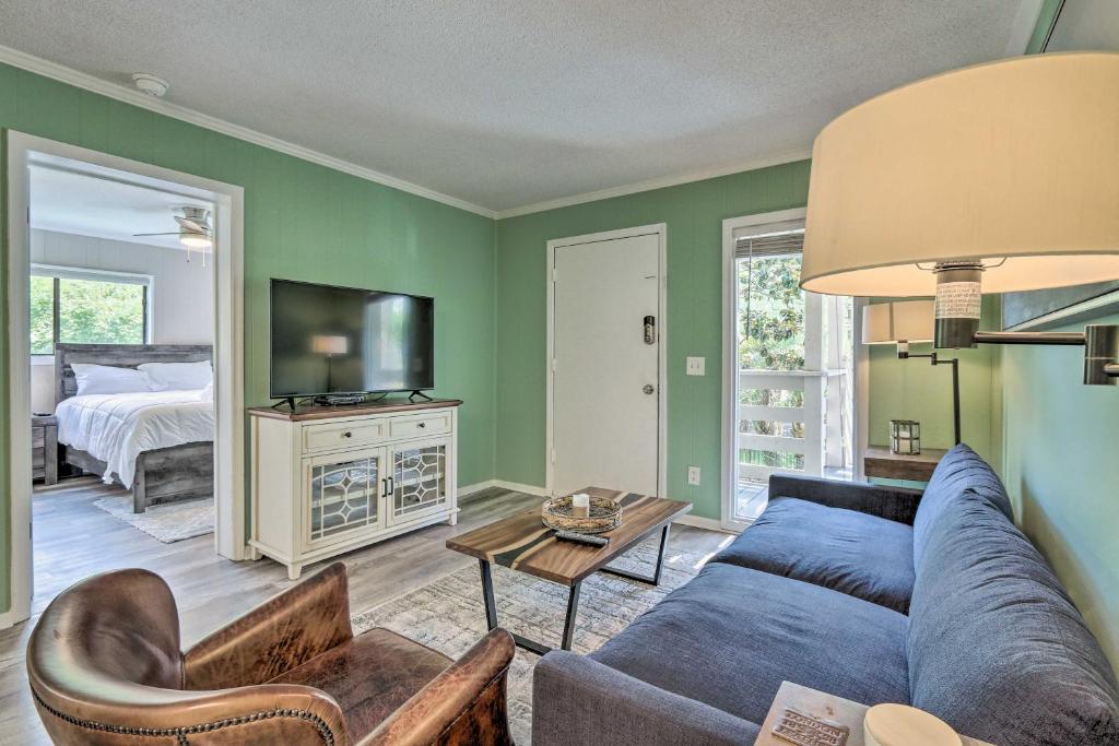 uma sala de estar com um sofá azul e uma cama em Convenient Hilton Head Island Condo with Pool! em Hilton Head Island