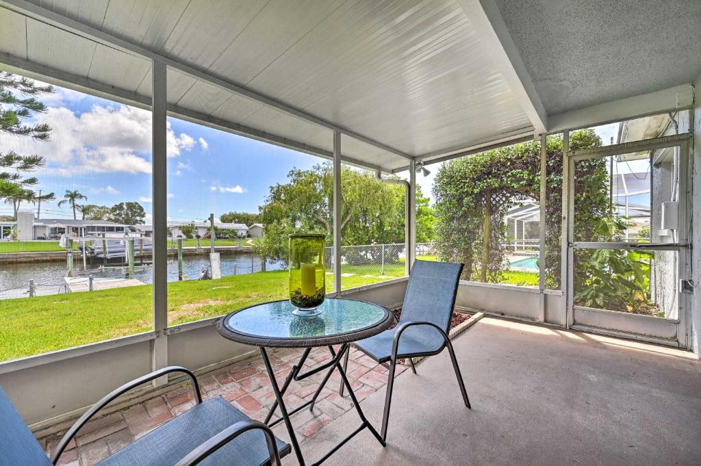 una mesa y sillas en un porche con vistas al agua en Canalfront New Port Richey Home with Boat Dock!, en New Port Richey