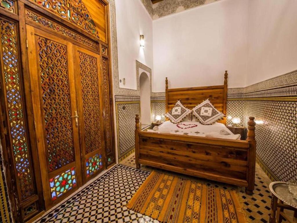 een slaapkamer met een bed in een kamer met patronen op de muren bij Charming Riad Ouliya in Fs in Fès