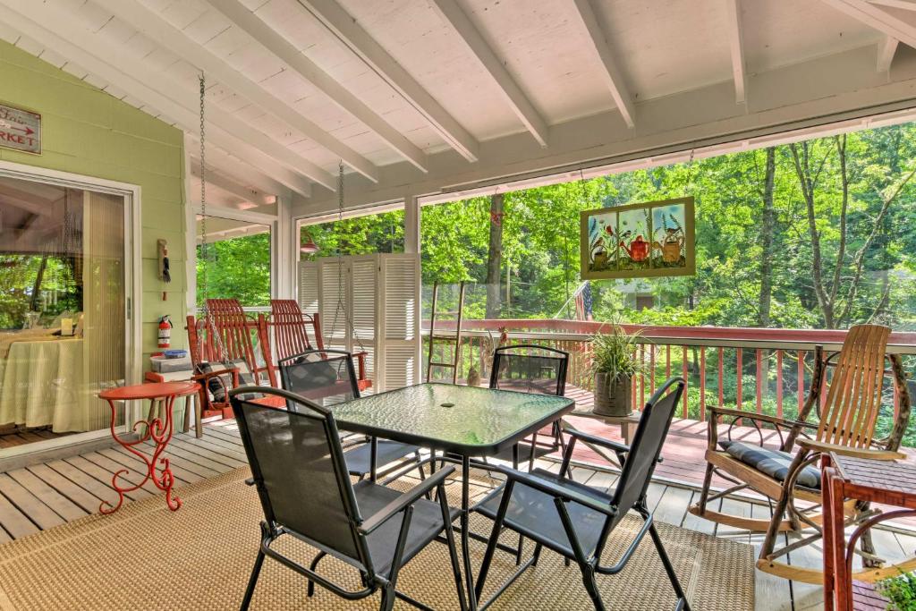 a screened in porch with a table and chairs at Tranquil Creekside Cottage with Deck and Lanai in Franklin