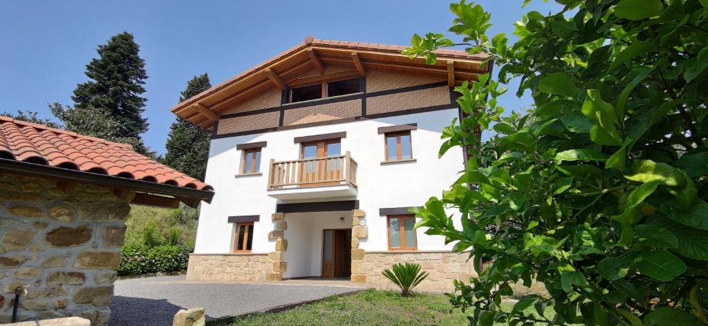 a large white house with a balcony at LAGA Surf VILLA by Urdaibai Rentals in Ibarrangelu