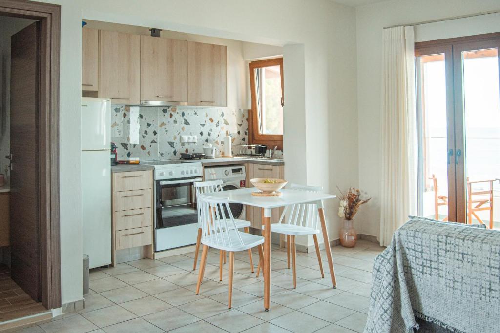 a kitchen with a table and chairs in a room at Apartment by the sea in Stalida