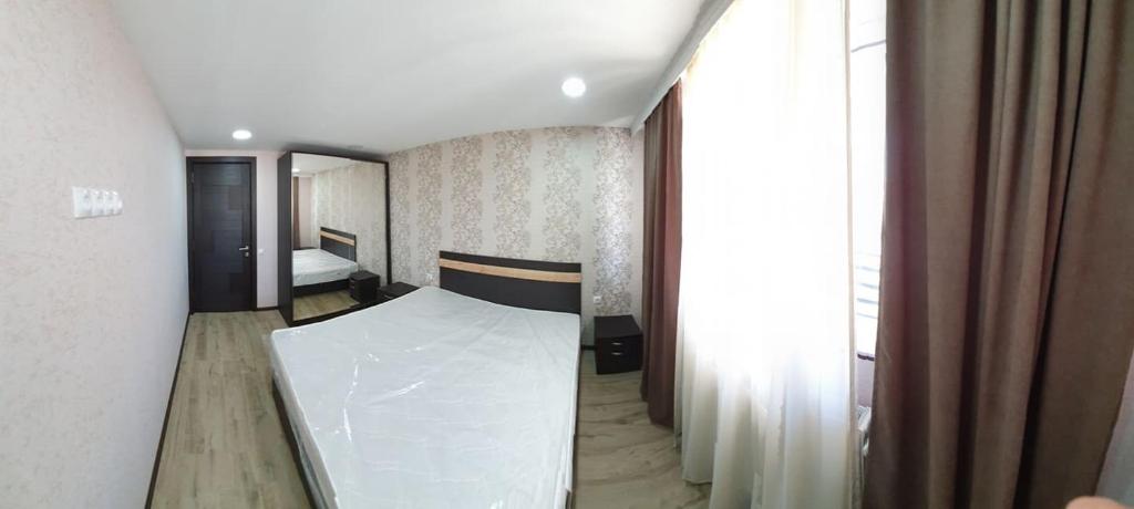 um quarto com uma cama e uma grande janela em Tbilisi apartments em Tbilisi