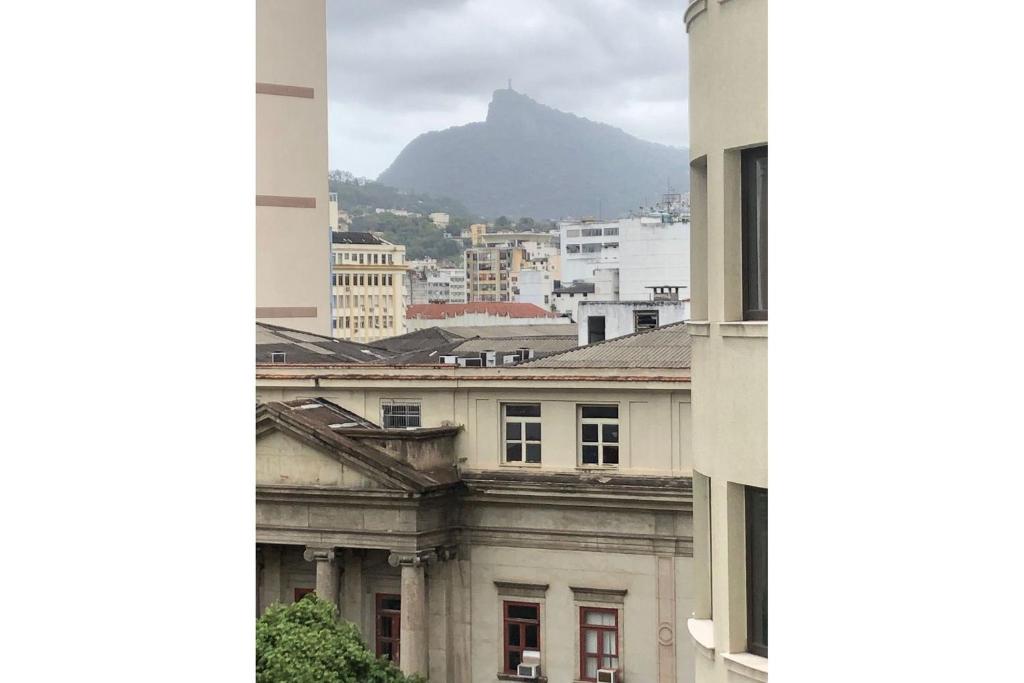 Blick auf eine Stadt mit einem Berg im Hintergrund in der Unterkunft Centro da cidade com vista para o Cristo in Rio de Janeiro