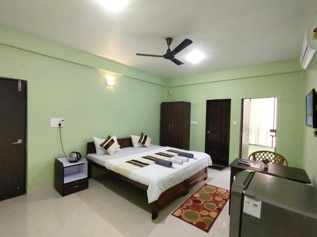 a bedroom with a large bed with a ceiling fan at The Narrow Way Edward Guest House in Candolim