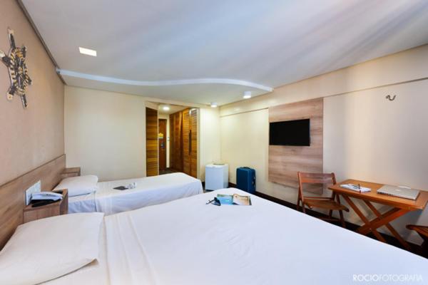 um quarto de hotel com duas camas e uma televisão em Hotel Privê do Atalaia em Salinópolis