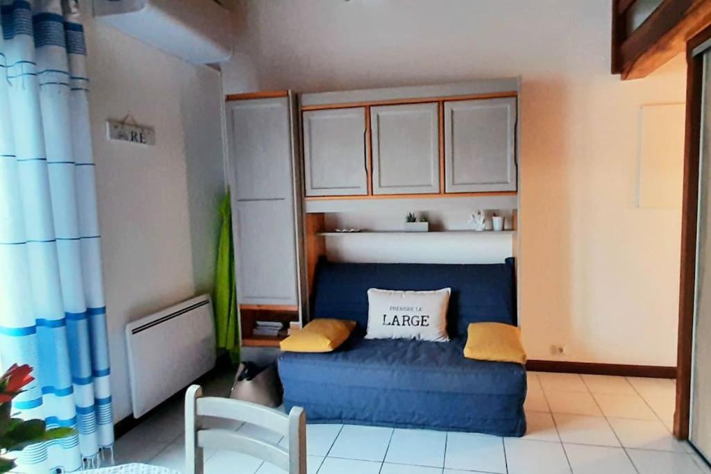 a small kitchen with a blue couch in a room at Délicieux moment de détente au coeur de Saint Martin de Ré in Saint-Martin-de-Ré