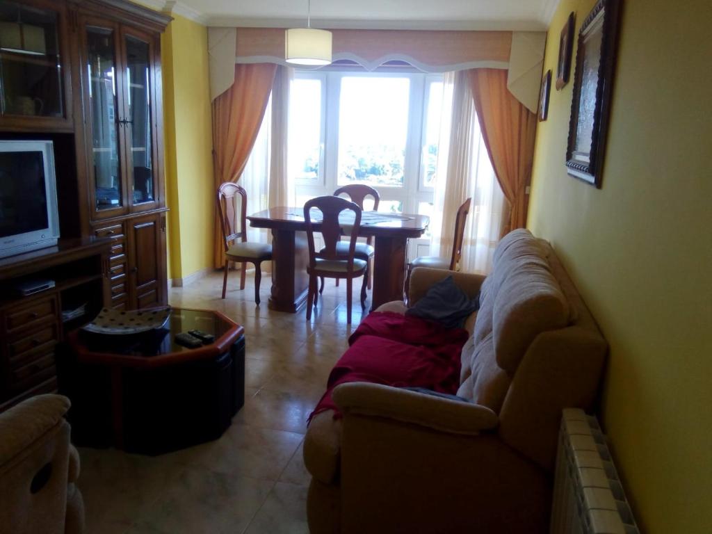 ein Wohnzimmer mit einem Sofa und einem Tisch in der Unterkunft Piso in Boiro