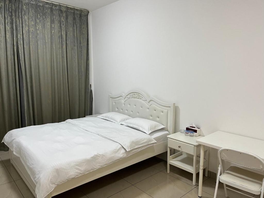 1 dormitorio con cama blanca y escritorio en Wehome 忆江南民宿 en Dubái