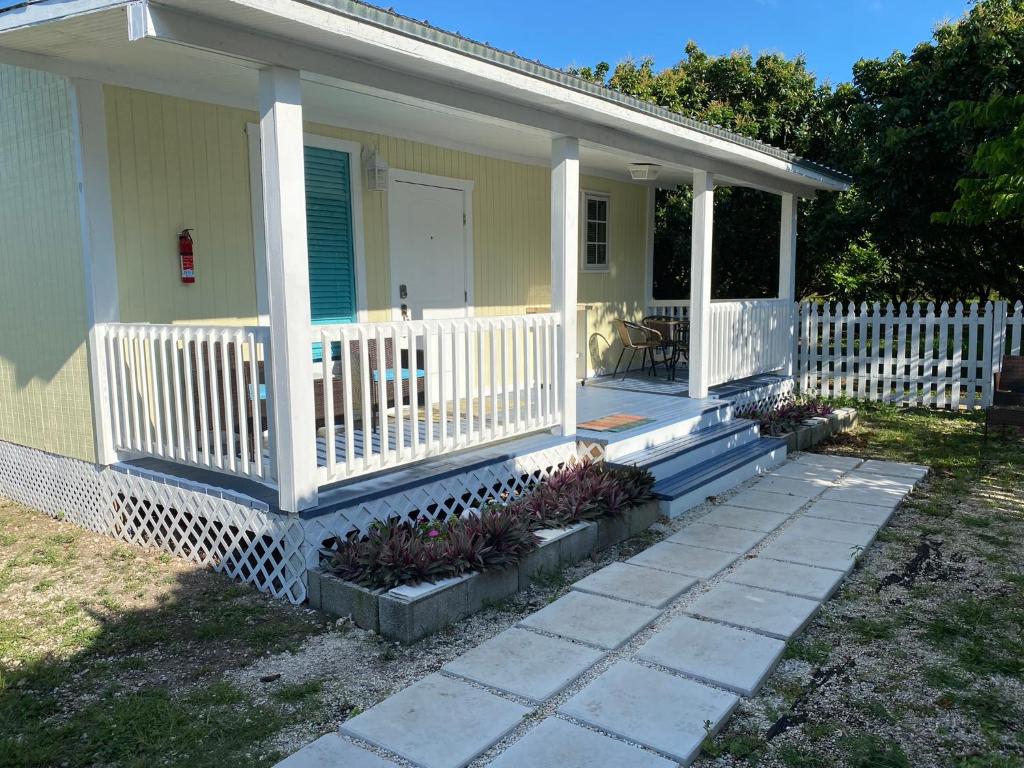 a yellow house with a white fence and a porch at Maria's Los Cirhuelos in Homestead