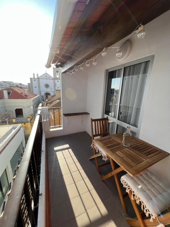 balcón con mesa de madera y sillas en el techo en Residencial Mira-Mar, en Peniche