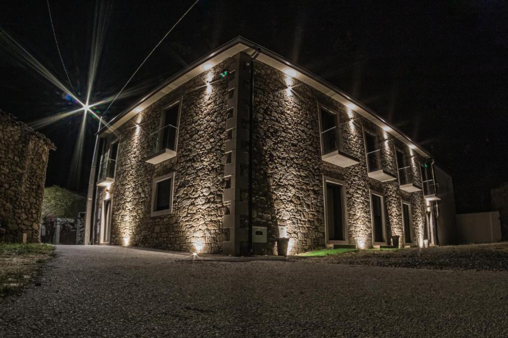 ein Backsteingebäude mit Lichtern in der Nacht in der Unterkunft Casas de Campo Curral Grande - By Cimo da Quinta in Miranda do Douro