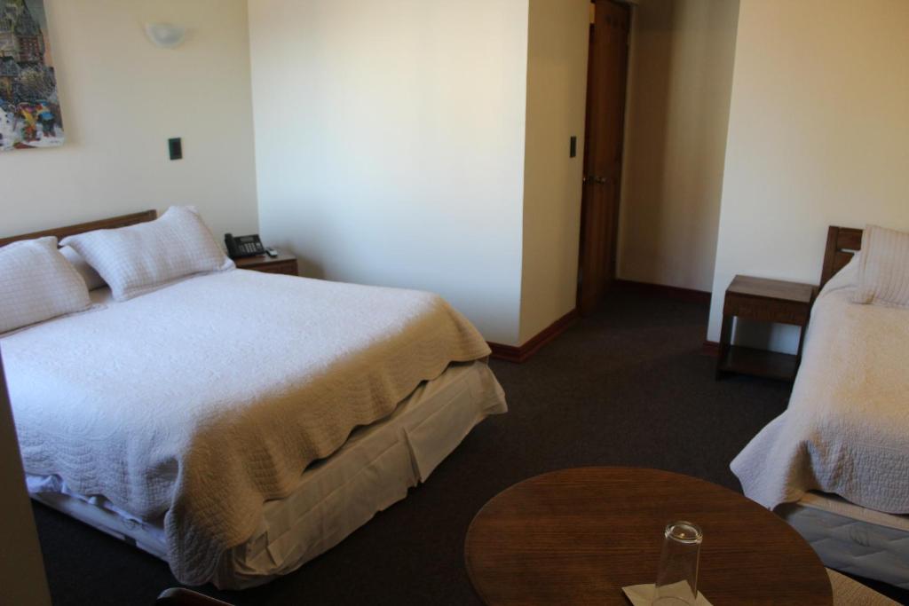 Habitación de hotel con cama y mesa en Hotel Antupiren en Puerto Montt