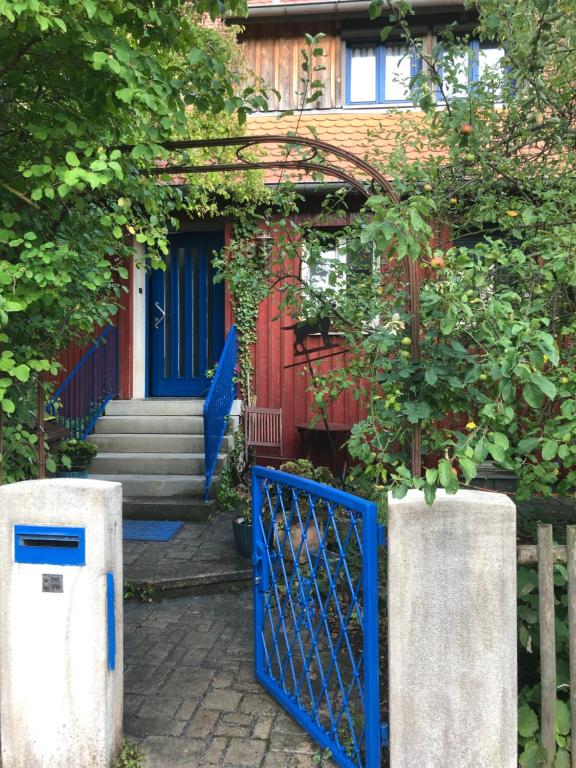 a blue gate in front of a house at Ferien- und Messeappartement Schwaig in Schwaig bei Nürnberg