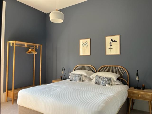 a bedroom with a large bed with blue walls at Field Maple -free parking -Grade II listed- first floor two bedrooms apartment in Huntingdon