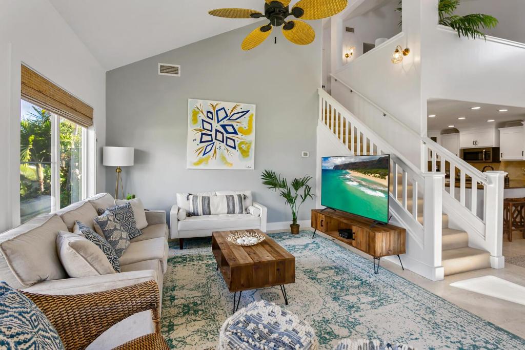 a living room with a couch and a tv at Koolkondo Luxury Designer Condo in Koloa