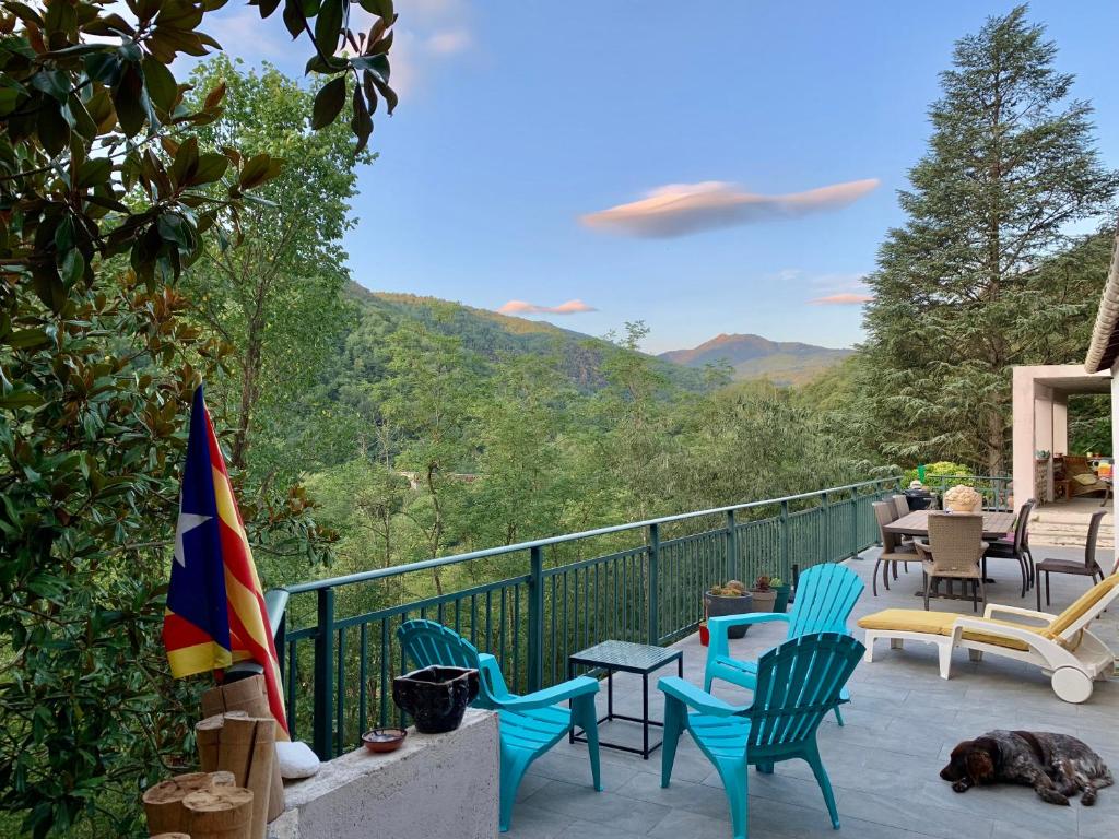 a patio with chairs and a flag and mountains at Le Gite de Sébastien à Manyaques in Le Tech