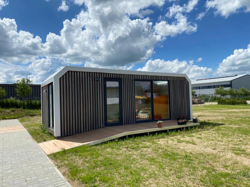 a small black modular building on a grass field at EcoRelax in Błotnik