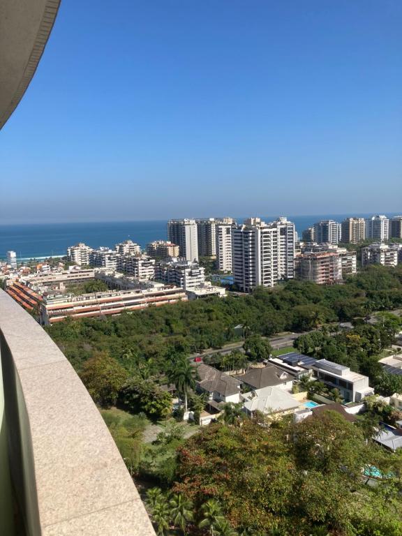 uma vista para uma cidade com edifícios e o oceano em Mediterrâneo Flat Barra da Tijuca no Rio de Janeiro