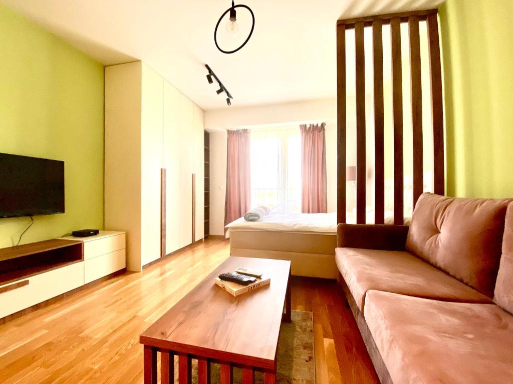 Una sala de estar con un sofá y una mesa de café. en Urban Garden APARTMENT, en Skopje