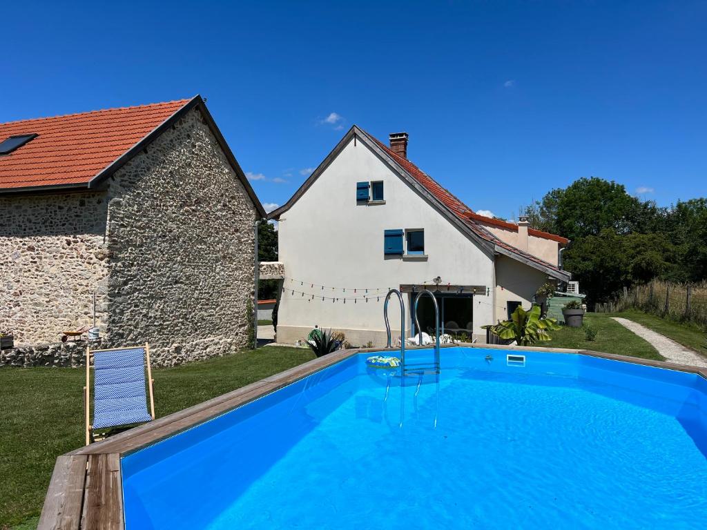 a swimming pool in front of a house at Les volets bleus 