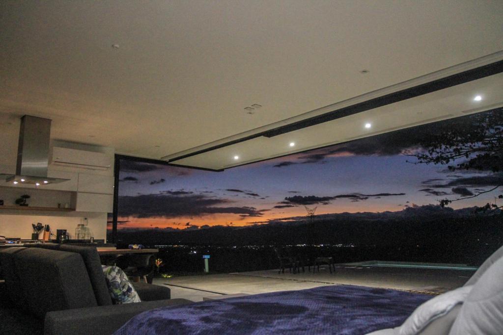 Habitación con una gran pantalla de proyección con puesta de sol en LoftMerak en Pereira