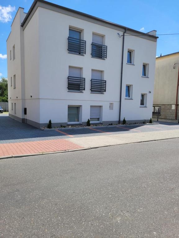 un bâtiment blanc sur le côté d'une rue dans l'établissement Paloma9, à Krotoszyn