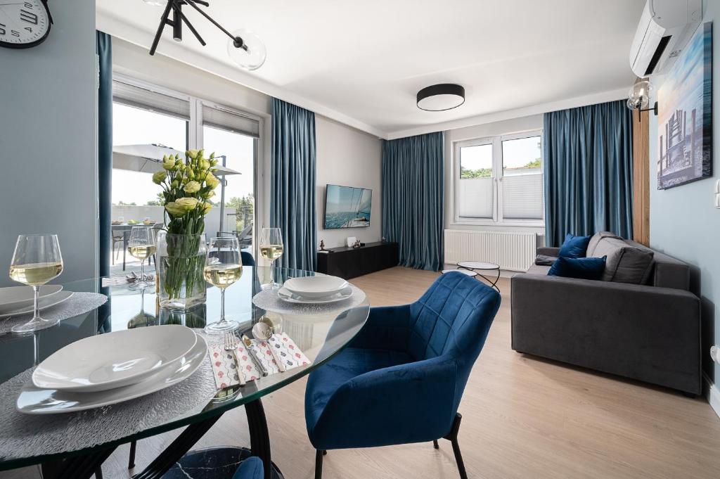 加茨比亞格拉的住宿－Morskie Apartamenty Albatros i Góral，客厅配有桌子和蓝色椅子