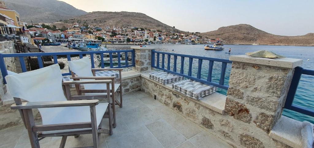 uma varanda com cadeiras e vista para a água em Halki Sea Breeze - a waterfront villa em Halki