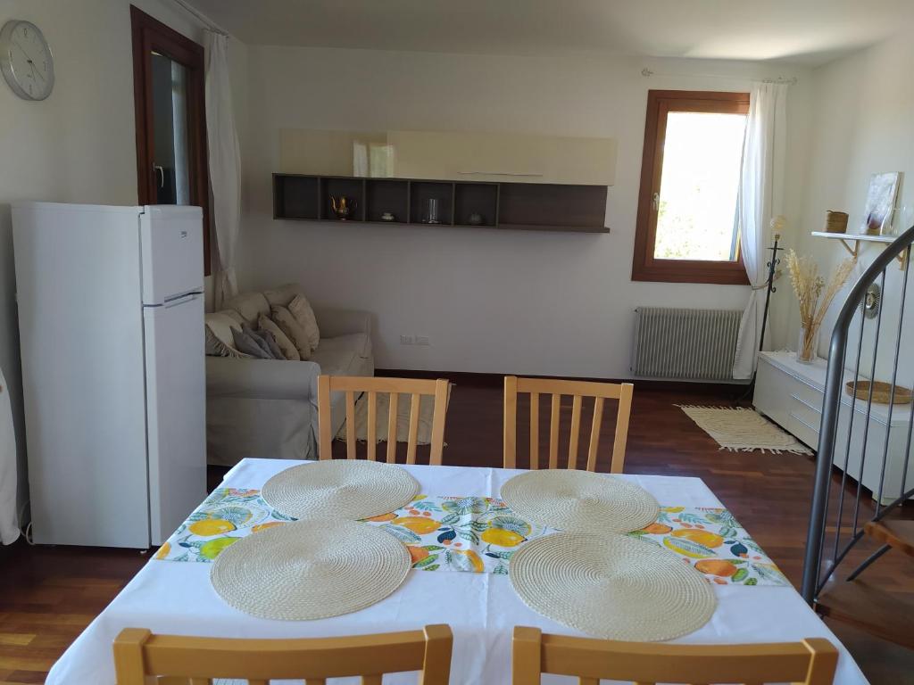 特雷維索的住宿－L'appartamento Italia B.，厨房配有带四把椅子的桌子和冰箱。