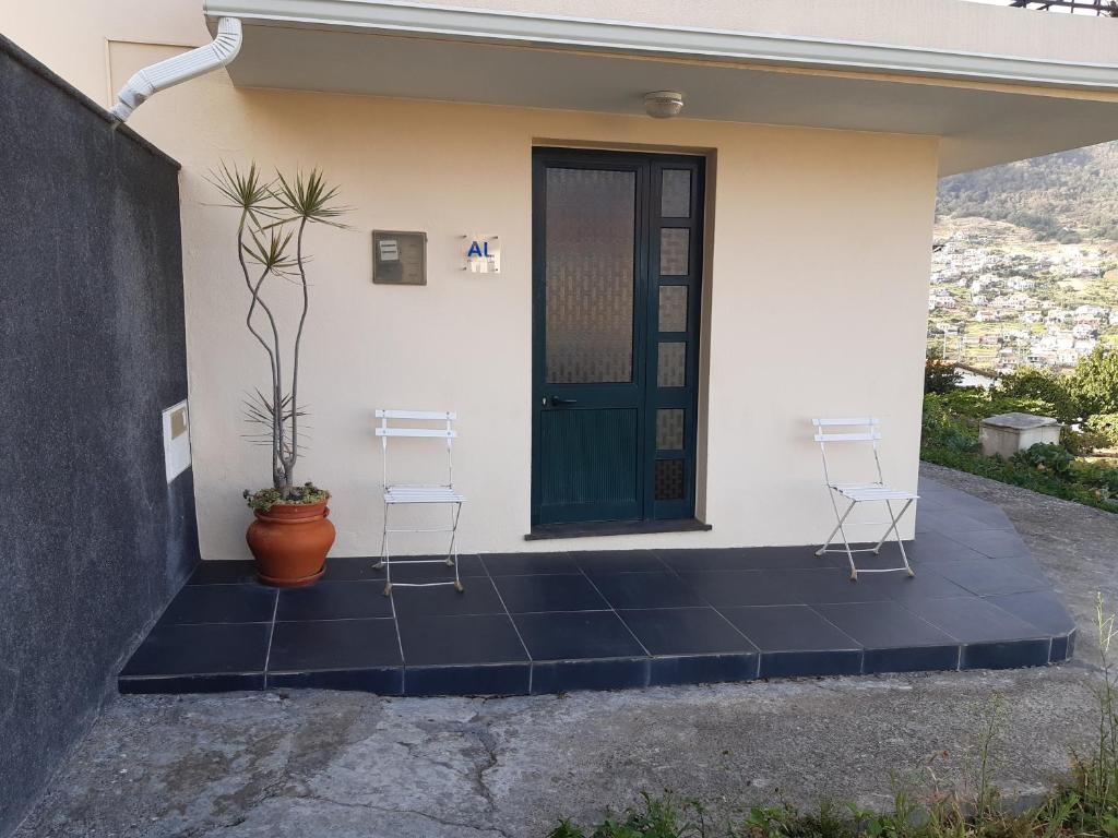 a house with two chairs and a door at Apartamento Piquinho in Machico